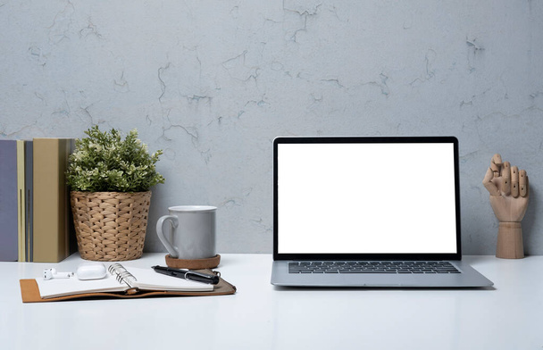 Ноутбук компьютер, кофейная чашка, книги и чехол на белом столе. Бланк-экран для рекламного текста. - Фото, изображение
