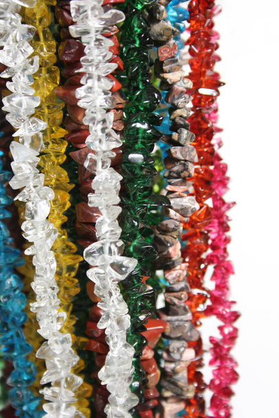 Hilos de coloridos granos de piedra natural y vidrio para la venta en la tienda de suministros de artesanía - Foto, imagen