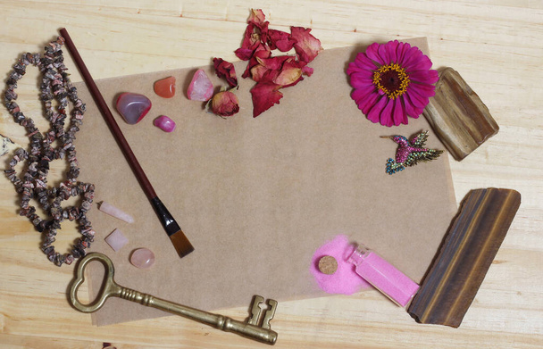 Ροζ λουλούδι με ροζ πέτρες και ορείχαλκο κλειδί σε παλιό χαρτί ροζ φόντο θέμα - Φωτογραφία, εικόνα
