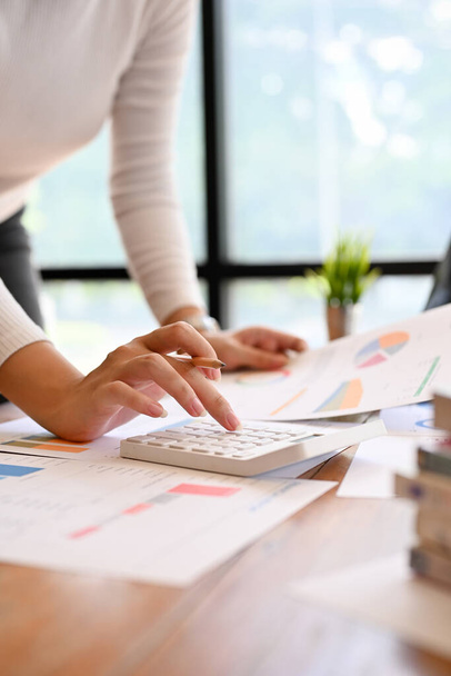 Imagem de perto de uma empresária profissional ou trabalhadora financeira usando uma calculadora, trabalhando no relatório em sua mesa. - Foto, Imagem