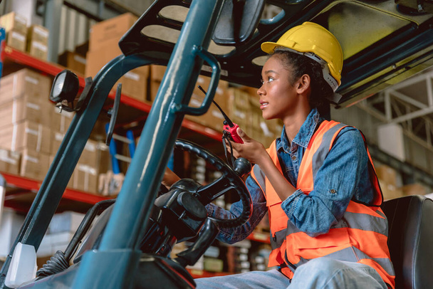African black woman cargo worker work in warehouse working staff forklift driver command loading with ham radio. - Foto, Imagem