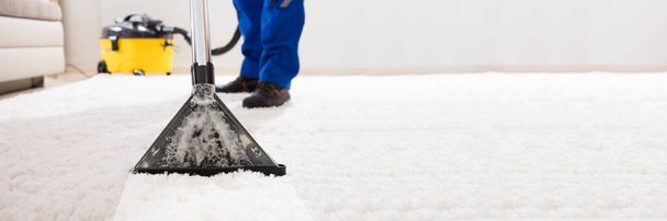 Close-up Of A Janitor Cleaning Carpet With Vacuum Cleaner At Home - Foto, immagini