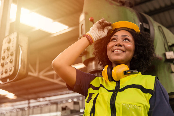 American black women teen worker enjoy working labor in industry factory with heavy steel machine happy smiling. - Foto, afbeelding