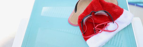 Santa Claus hat and accessories for swimming in the pool, close-up. New Year in warm countries, winter recreation on the water - Photo, Image