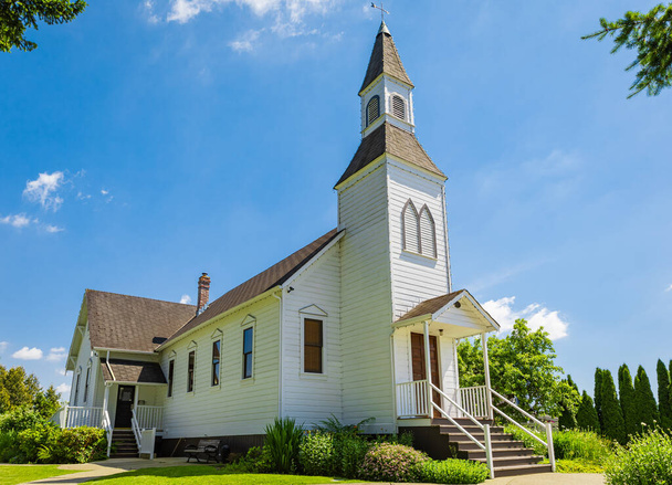 Na zewnątrz kościoła Little White Country w słoneczny dzień i błękitne niebo w tle. Piękny tradycyjny kościół na wsi Kanada-Czerwiec 30,2022-Langley BC-Nikt, zdjęcie z podróży, kopia miejsca na tekst - Zdjęcie, obraz