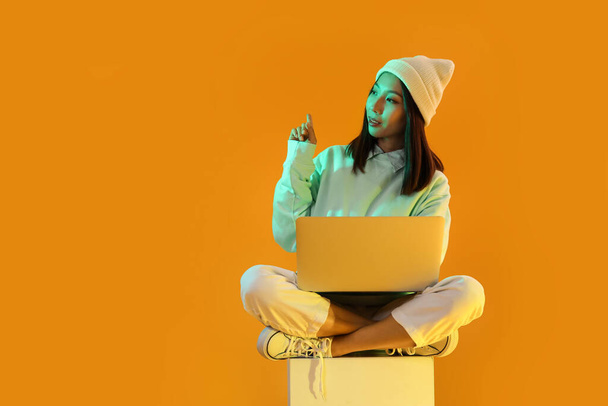 Nő ázsiai blogger laptop narancssárga háttér - Fotó, kép