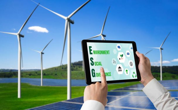 Groene business transformatie voor milieubesparing en ESG business concept. Zakenman die tablet gebruikt om bedrijfsdoelen te stellen voor milieuvriendelijk beheer en alternatieve schone energie. - Foto, afbeelding
