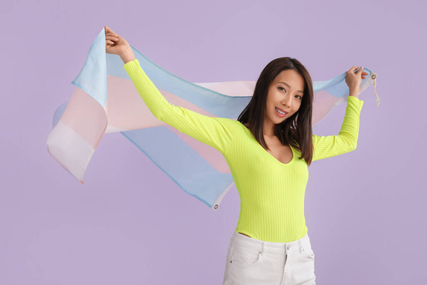 jong aziatisch vrouw met transgender vlag op lila achtergrond - Foto, afbeelding