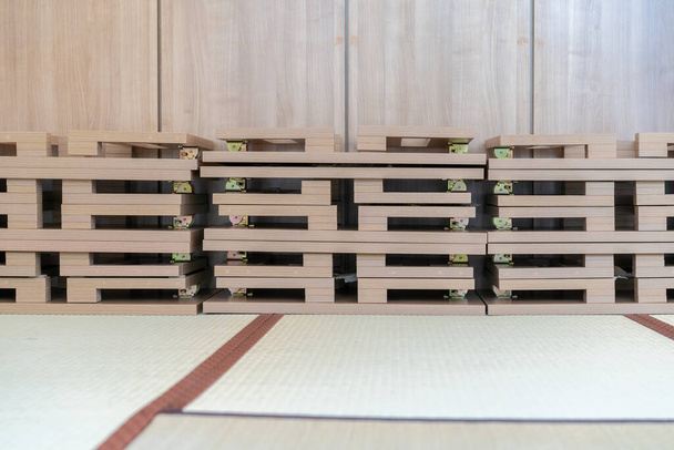 Japoński składany stół z drewna jest ustawiony w środku obrazu, nadaje się do jedzenia lub czytania, na matach tatami. - Zdjęcie, obraz