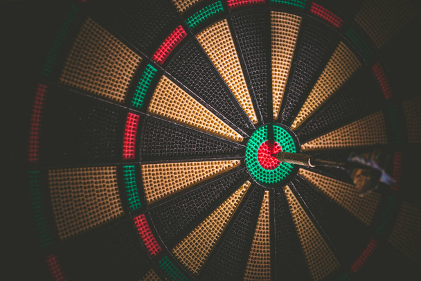 Business concept - Target and goal as concept. Dart arrow hit on bulleyes of dartboard to represent that the business reached the target - 写真・画像