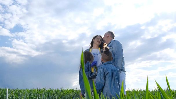 Happy family walks on a green field, they are dressed in denim clothes. Family concept - Foto, Imagem