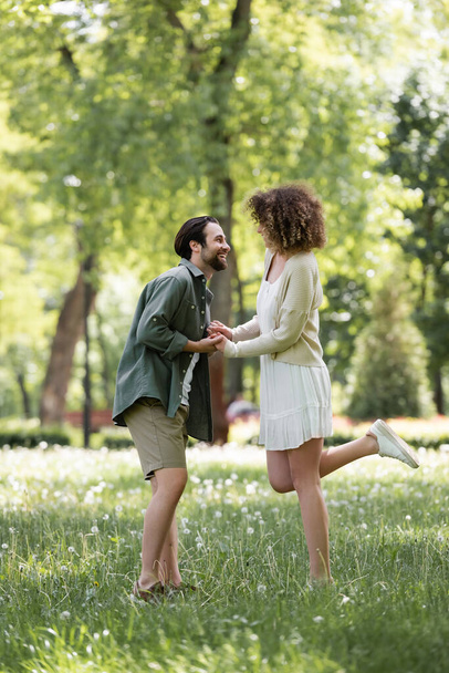 full length of happy young couple having date in green park  - 写真・画像