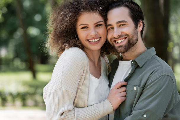 Porträt eines fröhlichen jungen Paares, das lächelt und in die Kamera blickt - Foto, Bild