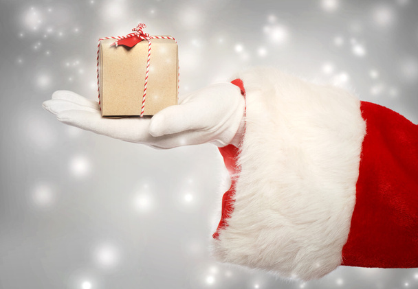 Santa claus giving a small christmas present box  - Фото, изображение