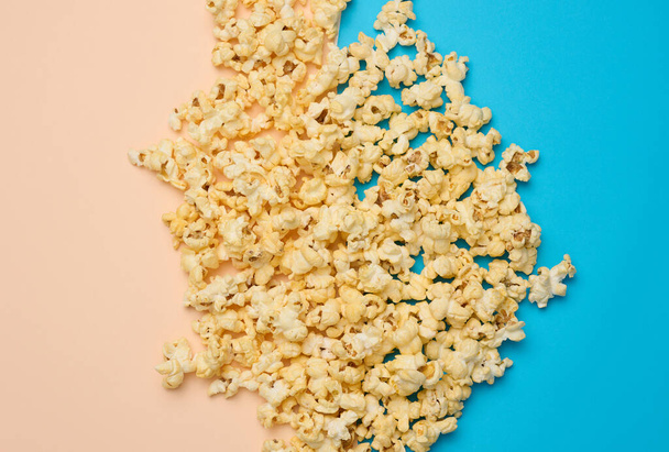 Masa smażonego popcornu z serem na niebieskim tle, widok z góry - Zdjęcie, obraz