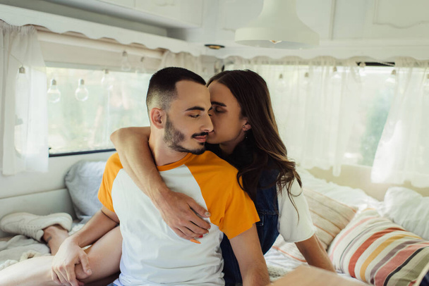 gay man with long hair hugging bearded boyfriend in van  - Photo, Image