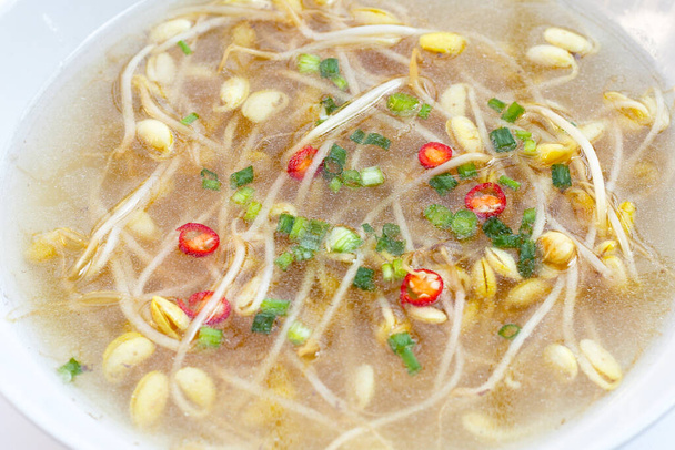 Sojabonen spruiten soep in witte kom - Foto, afbeelding