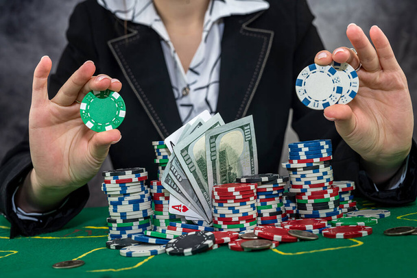 女性プレーヤーはお金のチップをカウントし、カジノでポーカーをプレイすることで賭けを上げる。ギャンブルの概念 - 写真・画像