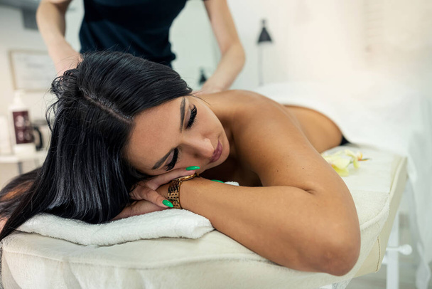 gros plan d'un thérapeute professionnel faisant des massages sur le dos et les épaules. Belle jeune femme relaxante au spa de beauté - Photo, image