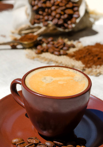 Taza de café en el fondo de granos de café en la mesa. Arabica es el tipo más común de café. - Foto, imagen