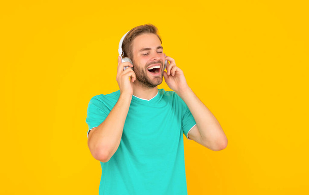 happy guy with bristle listen music on yellow background, music. - Zdjęcie, obraz