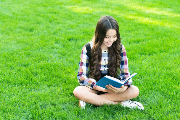 happy teen girl sit on grass reading book. - Photo, Image