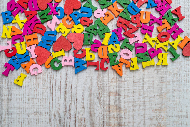 Stapel von bunten kleinen Holzbuchstaben für die Grundschule. Englische Buchstaben in chaotischer Reihenfolge auf Holztisch - Foto, Bild