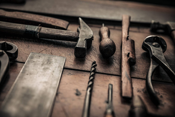 close up picture of some carpentry tools on working table, hammer, square, drill, spokeshave, pincers and gouge for a craftsmanship concept - Fotoğraf, Görsel