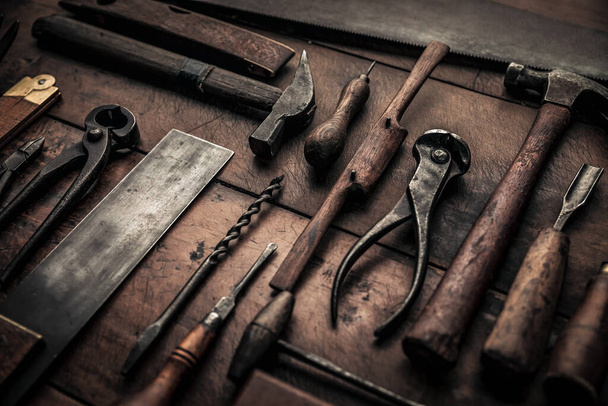 close up picture of rusty pinces, hammer, drilles, screwdriver, spokeshave and others on wooden working table  - 写真・画像