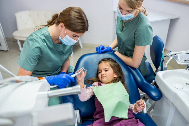 joven dentista mujer cepillarse los dientes para niña niña. El concepto de cepillarse los dientes en un niño - Foto, Imagen