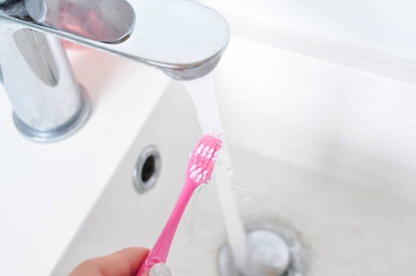 roze tanden borstel voor dagelijkse schoonmaak, ochtend routine, badkamer accessoires - Foto, afbeelding