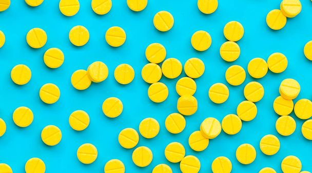 Yellow tablets of Paracetamol on blue background. - Photo, image