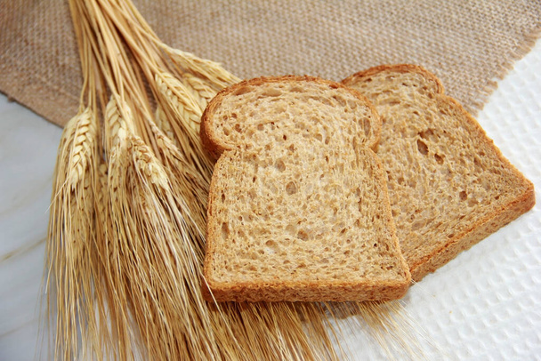pezzi quadrati di pane tostato di segale e spighe secche di grano - Foto, immagini