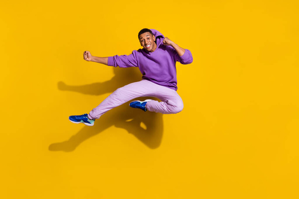 Full length body size view of handsome trendy strong guy jumping fighting isolated on bright yellow color background. - Valokuva, kuva