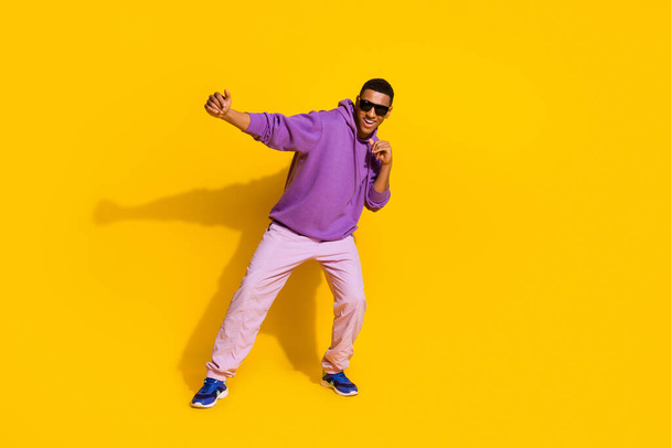 Full length body size view of attractive cheerful guy dancing fighting moving isolated over vivid yellow color background. - Foto, imagen