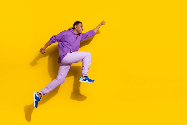 Full length body size view of handsome trendy strong cheerful guy jumping striving isolated on vivid yellow color background. - Foto, Imagem
