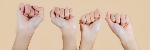 Несколько просмотров четырех рук с сжатым кулаком, женские руки на бежевом фоне - Фото, изображение