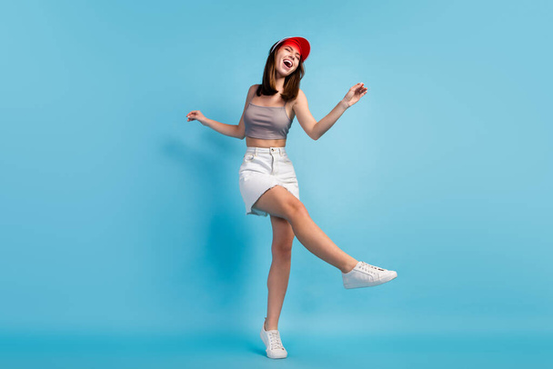 Full size photo of young cheerful girl happy positive smile have fun dance cap isolated over blue color background. - Foto, Bild