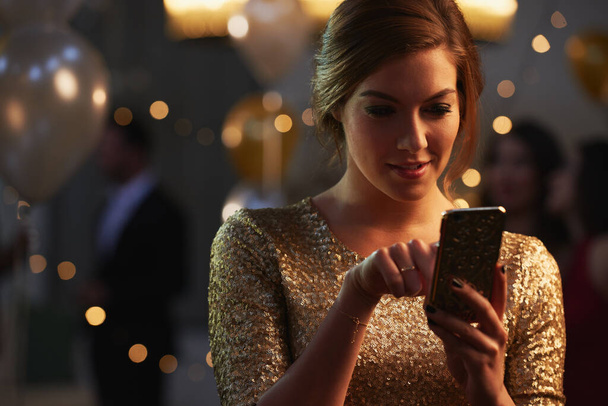 Cropped shot of an attractive young woman checking her messages while in a nightclub. - Fotoğraf, Görsel