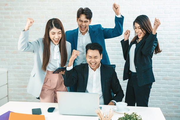 Happy diverse employees team celebrating teamwork success, business achievement at meeting.Group of successful happy business people working as a team in office on meeting. - 写真・画像