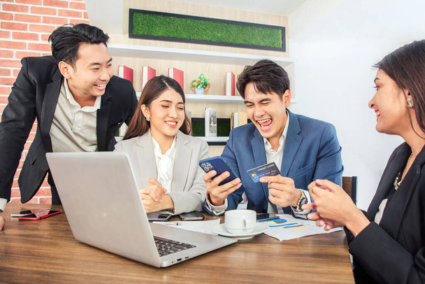 Junge asiatische Geschäftsleute bestellen Mittagessen per mobiler Anwendung während einer Videokonferenz im Büro - Foto, Bild