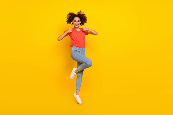 Full body photo of excited attractive lady jump two hands demonstrate thumb up isolated on yellow color background. - Фото, изображение