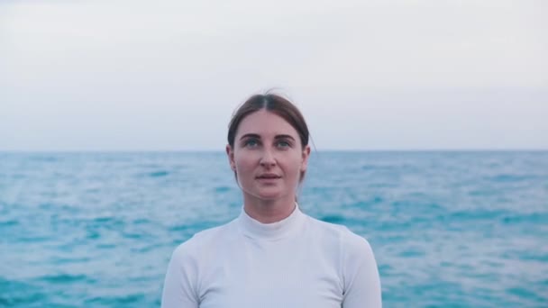 Una donna adulta che respira sulla riva del mare blu. Ritratto - Filmati, video