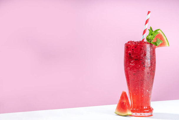 Освіжаючий холодний літній напій слизький кавун, десертний напій з льодом Граната, подрібнений кавуновий лід на модному висококольоровому біло-рожевому фоновому копіювальному просторі
 - Фото, зображення