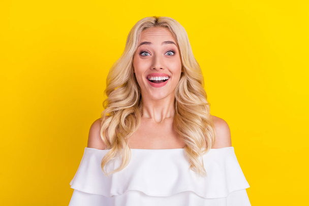 Portrait of attractive amazed cheerful wavy-haired girl good news reaction isolated over bright yellow color background. - Zdjęcie, obraz