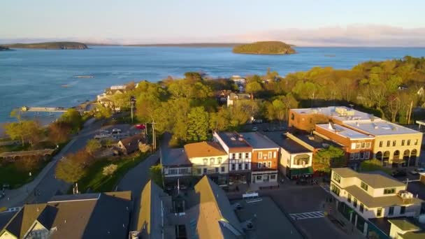 Bar Harbor historyczne centrum miasta widok z lotu ptaka o zachodzie słońca, z Cadillac Mountain w Acadia National Park w tle, Bar Harbor, Maine ME, USA.  - Materiał filmowy, wideo