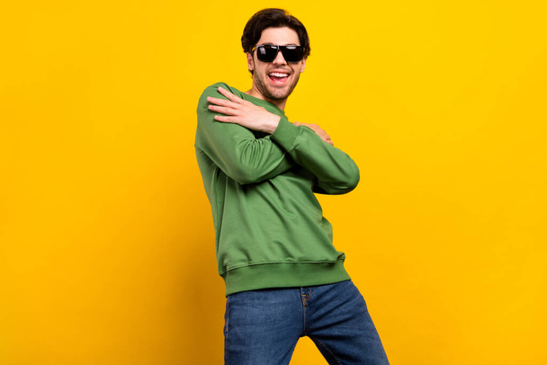 Photo of young positive happy cheerful man wear sunglass dance hands crossed isolated on yellow color background. - Valokuva, kuva