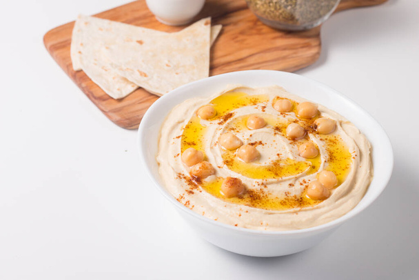 Хумус в тарелке с горохом, копченой паприкой, оливковым маслом и  - Фото, изображение