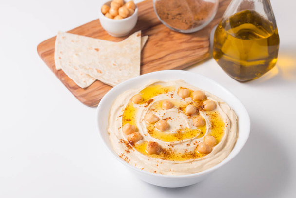 Hummus in een bord met kikkererwten, gerookte paprika, olijfolie en  - Foto, afbeelding