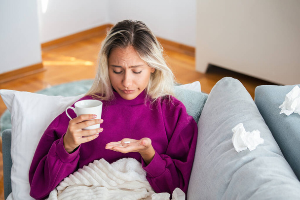 Millennial ill sick woman taking painkiller medicine to relieve stomachache pain sit on bed in the morning - Foto, Imagem